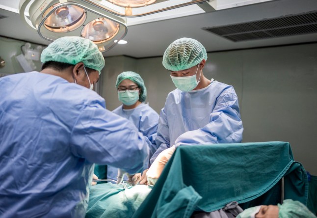 Medical team performing a procedure on a patient lying on a table in the operating room of a hospital