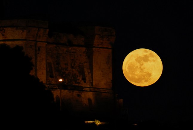 A full moon known as the "Flower Moon" rises behind the 17th century Fort St Lucian, as seen from Birzebbuga, Malta, May 12, 2025. REUTERS/Darrin Zammit Lupi