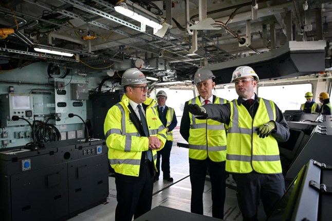 Britain's Prime Minister Keir Starmer (L) and Britain's Defence Secretary John Healey (C) listen to Type 26 Programme Director, BAE Systems David Shepherd (R) during a visit to the BAE Systems'Govan facility, Glasgow.